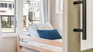 A bedroom with a bed, a window, and a door.