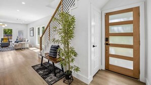 A modern interior with a staircase, a wooden door, and a living area with a sofa and a coffee table. - Cozy East Dallas Escape Minutes to Deep Ellum (Dallas)