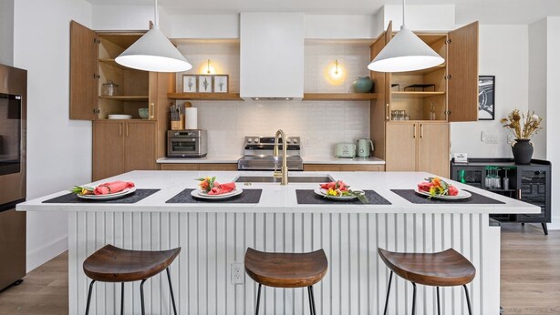 A modern kitchen with a central island, pendant lighting, and wooden cabinets. - Cozy East Dallas Escape Minutes to Deep Ellum (Dallas)
