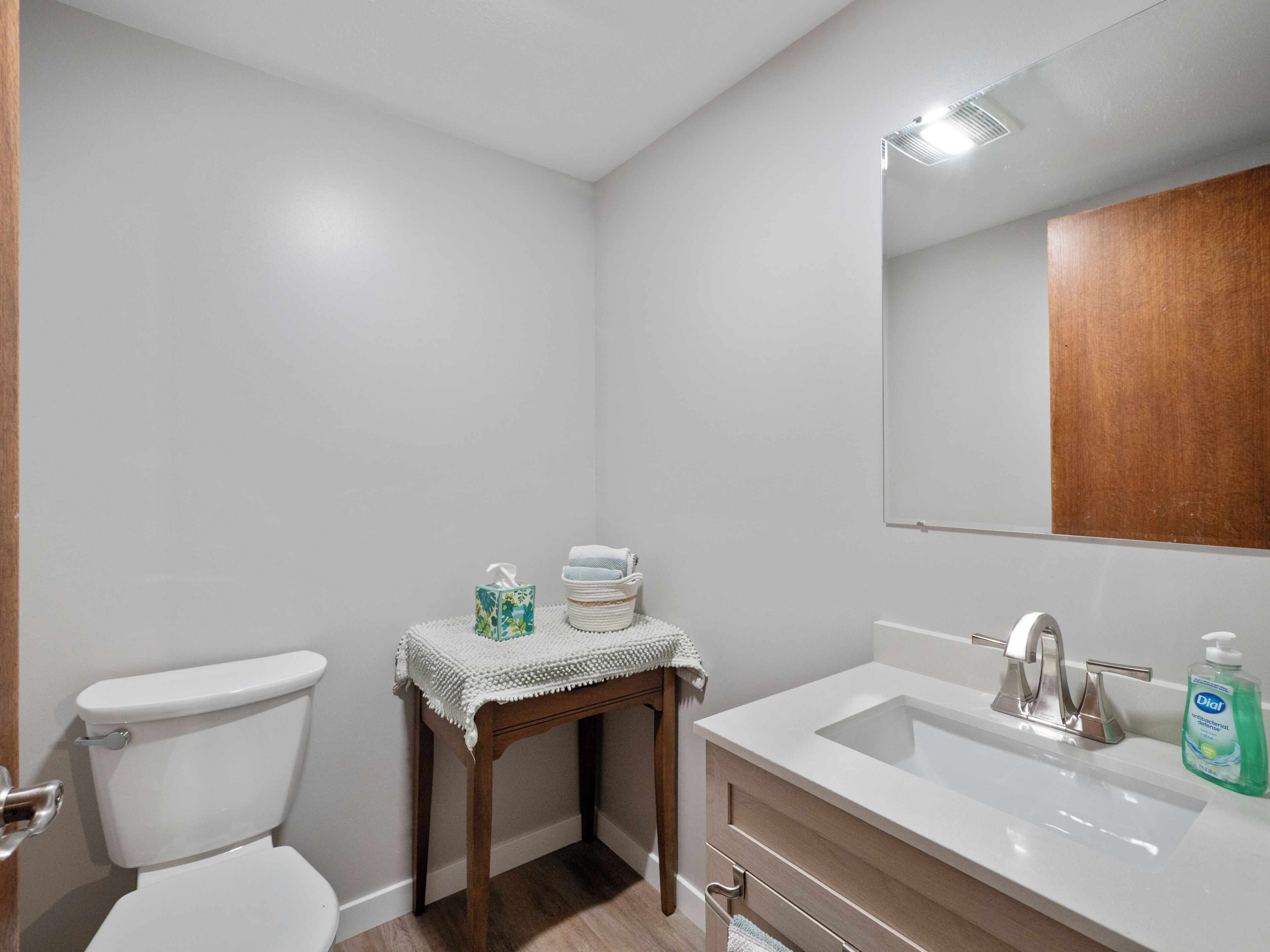 Un baño con inodoro, lavamanos y espejo.