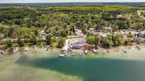 An aerial view of a lakeside property with multiple docks, a central building, and surrounding residential houses.