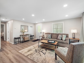 A living room with a sofa, coffee table, and a rug. -  NEW! Boater-Friendly Retreat Home, 2 Blocks from Chain O' Lakes Boat Landing (Waupaca)