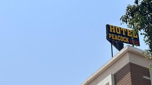 A building with a sign reading 'HOTEL PEACOCK ROOMS.' - Hotel Peacock  (Anand)
