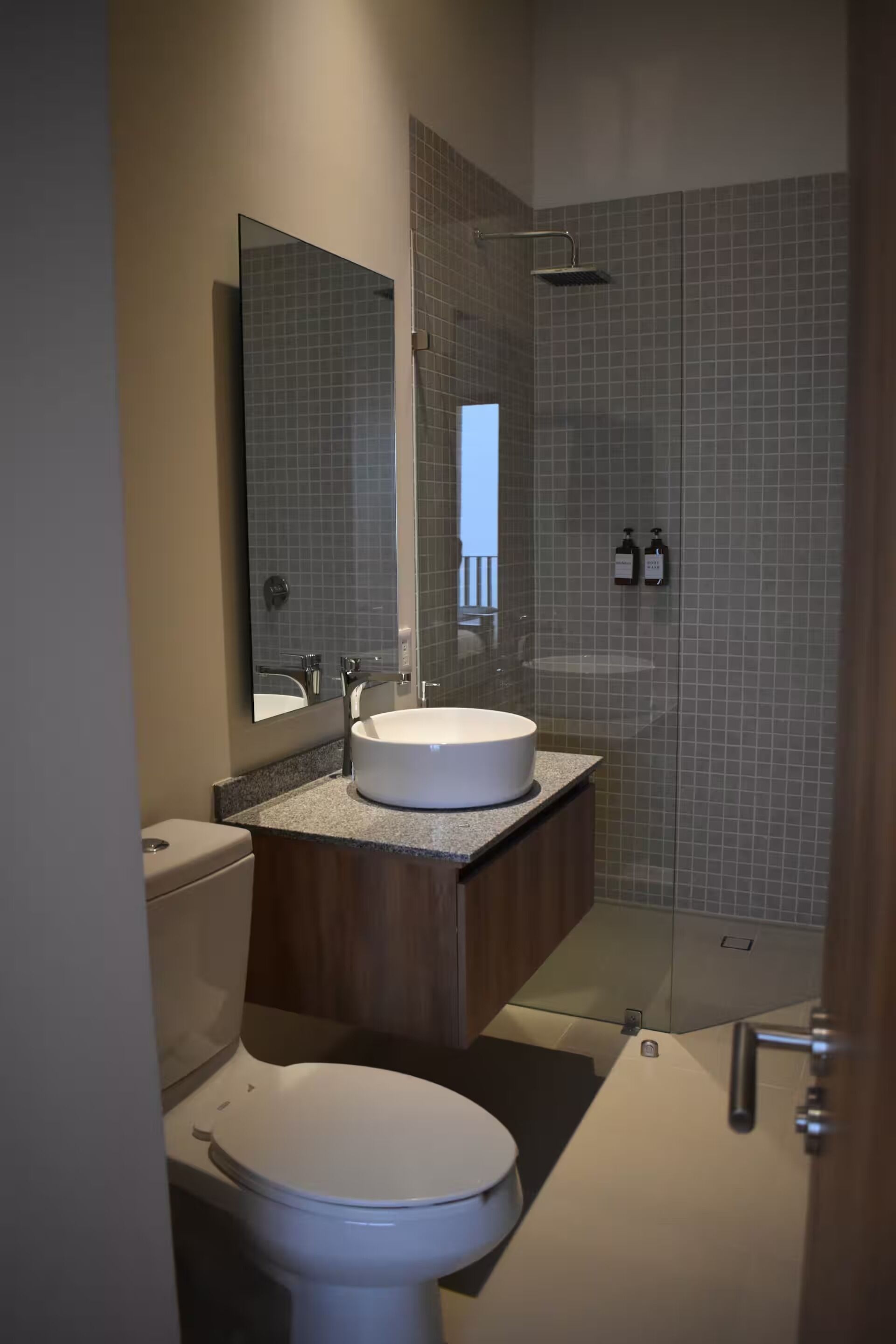A modern bathroom with a toilet, sink, and shower.