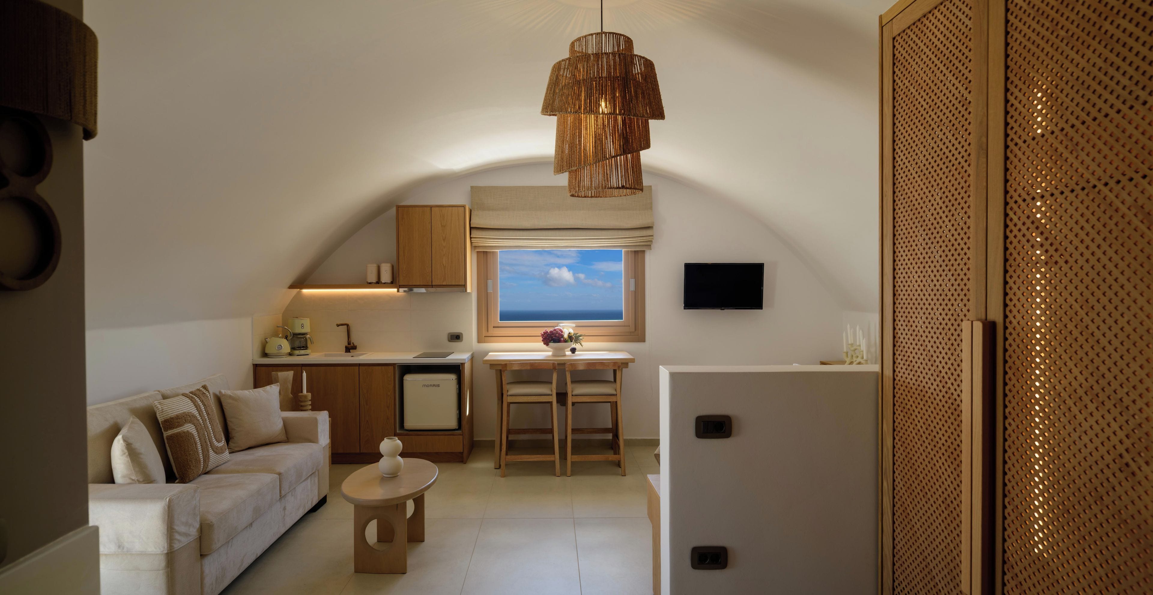 A compact living space with a kitchenette, a dining area, and a sofa.