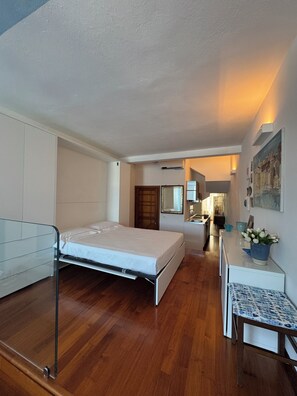 Ein Schlafzimmer mit Bett, Schreibtisch und einem Badezimmer im Hintergrund.