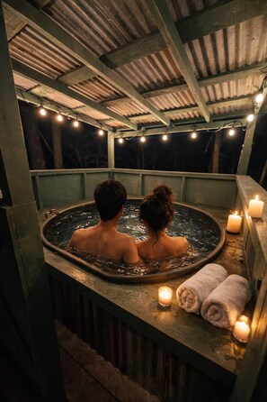 A couple in a hot tub with candles and towels, under a covered area with string lights. - Your Orders Have Arrived: Report to Mission Base, Unplug & Escape the Ordinary! (Vinita)