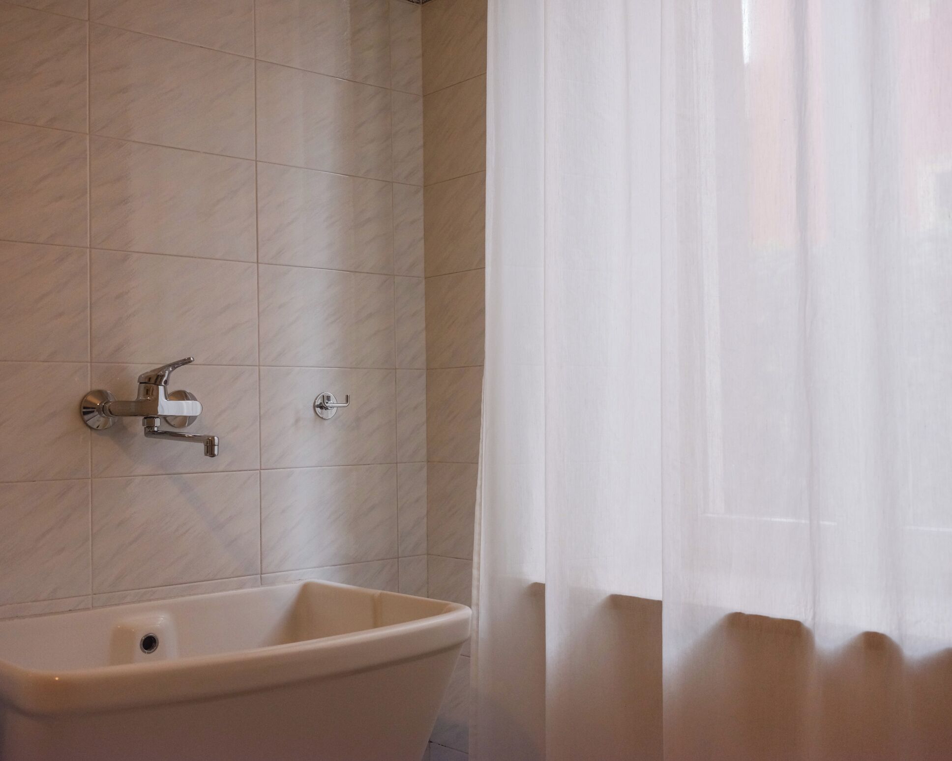 A bathroom with a sink, a mirror, and a shower curtain.