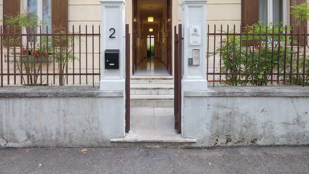 A building entrance with a number '2' on the gate, a mailbox, and a sign with Japanese characters. - Dimora Giardino di Giulietta (Verona)