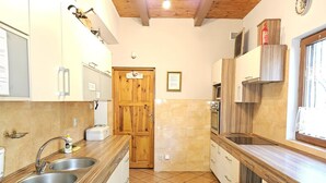 Una cocina con armarios de madera, un lavamanos doble y piso de baldosas.