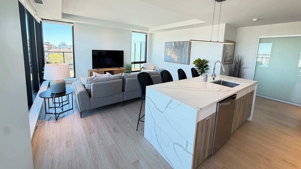 A modern apartment with a living area, kitchen, and dining space. - Waterview 2 BR / 2 Bath penthouse in Northend HFX. (Halifax)