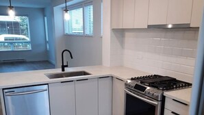 Uma cozinha moderna com máquina de lavar louça, fogão e forno.