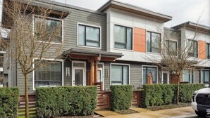 Uma fileira de casas geminadas modernas com fachada uniforme, entrada por portão e um veículo estacionado.
