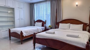 A hotel room with two beds, a wardrobe, and a window with curtains. - Metra Tower (Phnom Penh)
