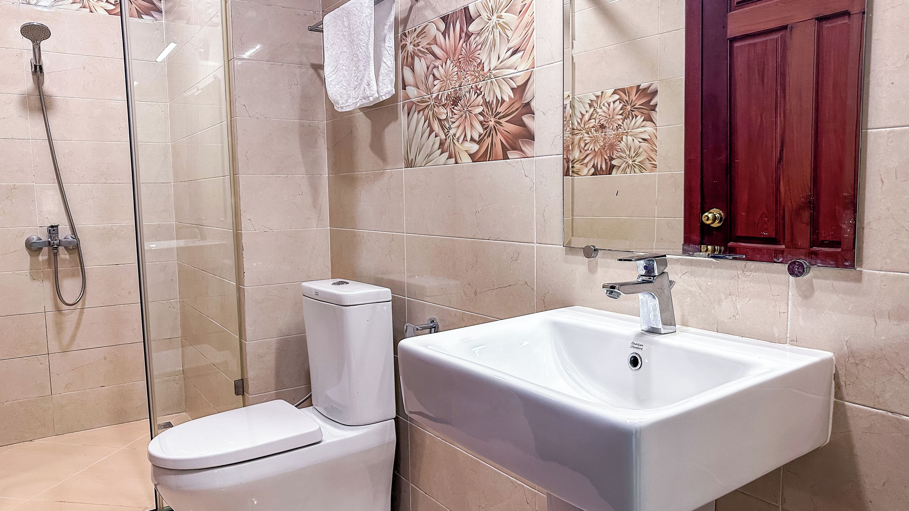 A bathroom with a toilet, a shower, and a sink.