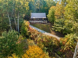 A cabin with a deck, surrounded by dense forest. - Bryson City Cabin, Game Loft, Hot Tub, Fire Pit (Bryson City)