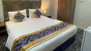 A hotel room with a bed, a wardrobe, a nightstand, and a lamp.