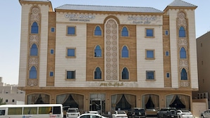 A multi-story building with 'QUIET ROOMS' signage, featuring a central arched window and decorative patterns.