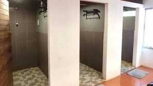 Ein Badezimmer mit gefliestem Boden, einer Duschkabine und einer Toilette.