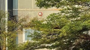 Ein Hosteleingang mit einer Bambuskonstruktion, einem Schild mit der Aufschrift 'You Empire Hostel' und einem Backsteinhaus im Hintergrund.