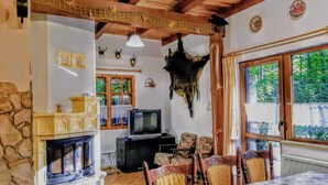 A rustic interior with a fireplace, wooden beams, and a dining area with a table and chairs. - Large House With Private Garden and Sauna (Purda)