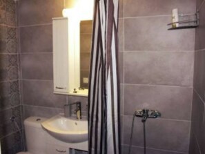 Ein Badezimmer mit Waschbecken, Spiegel und Duschvorhang.