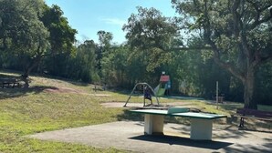 A park with a playground, benches, and trees. - Apartment parcs de grimaud (Grimaud)