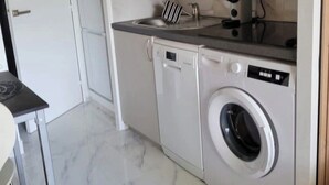 A compact kitchen with a washing machine, a microwave, and a sink. - Apartment parcs de grimaud (Grimaud)