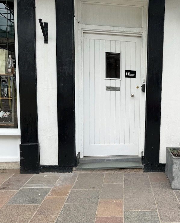 Eine weiße Tür mit schwarzem Rahmen, darüber ein kleines Fenster und ein Schild mit der Aufschrift '11' und 'Content View Apartment'.
