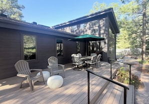 Eine Terrasse mit Gartenmöbeln, einem Tisch und Stühlen, umgeben von einem Geländer.
