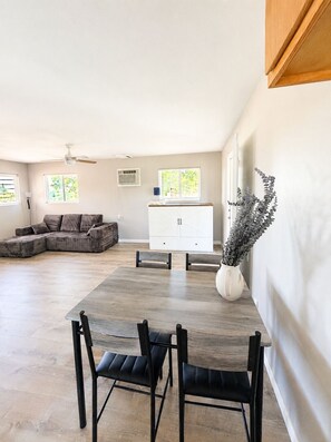 Un salon spacieux avec une grande table à manger, un canapé et un buffet.