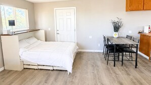 A bedroom with a bed, a desk, a chair, and a dining table. - Amador Wine Country Farmhouse Near Wineries (Plymouth)