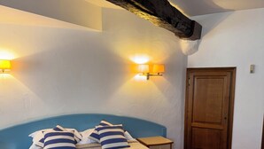 Un dormitorio con una cama, dos lámparas de noche, una puerta de madera y una alfombra roja.