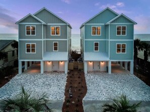 A symmetrical two-story house with a central walkway, surrounded by a paved area. - Gulf-Front Luxury Home with Private Pool, Beach Access & Bikes! (Panama City Beach)