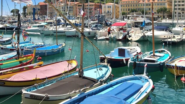 A marina with various boats docked, buildings in the background, and a clear sky. - Apt 4 guests Promenade des Anglais (Nice)