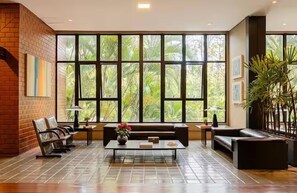 Eine großzügige Lobby mit einem großen Fenster, einem Sofa, einem Couchtisch und einer Ziegelwand.