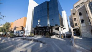 A modern building with a glass facade and a 'CROWN' sign. - 7Crown Tahliah Hotel (Riyadh)