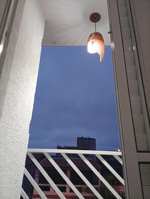 Un balcon avec vue sur le ciel et les bâtiments.