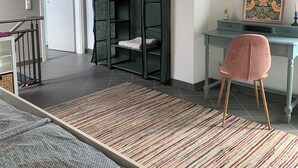 A room with a bed, a desk with a chair, a wardrobe, and a colorful rug. - Top location! Apartment at the foot of the Rhön, forest on the doorstep. Pet friendly! (Dipperz)