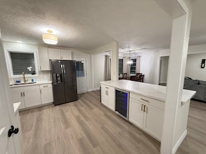A modern kitchen with white cabinetry, a stainless steel refrigerator, and a dishwasher. - 3-bedroom 2-bath home in Beaumont (Beaumont)