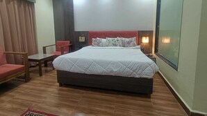 A hotel room with a bed, a chair, a small table, and a window. - Hotel O Aura Mall Bhopal (Bhopal)