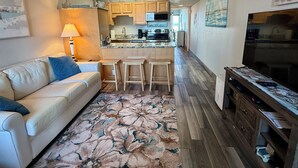 A living room with a sofa, a coffee table, a lamp, and a patterned rug. - Steps from the Beach with Gulf View Ground Floor (Fort Walton Beach)