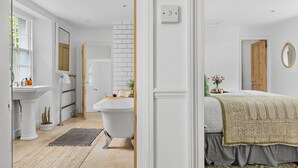 Ein Badezimmer mit einem weißen Waschbecken, einer Badewanne und einem Spiegel.