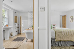 A bathroom with a white sink, a bathtub, and a mirror. - Lantern House - Historic Coastal Retreat with Hot tub, Sea Views & Garden (Torquay)