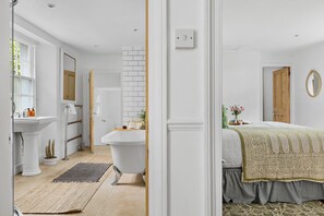 A bathroom with a white sink, a bathtub, and a mirror. - Lantern House in Torquay (Torquay)