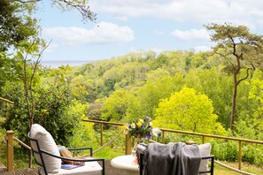 A terrace with two chairs, a table, and a vase of flowers. - Lantern House in Torquay (Torquay)