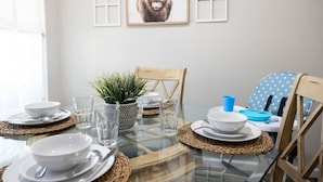 A dining table set with plates, bowls, glasses, and a potted plant. - Lux Modern Getaway At&t Stadium Views King Bed (Arlington)