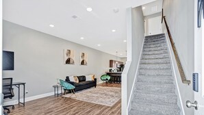 Una sala de estar moderna con una escalera que sube a un nivel superior.
