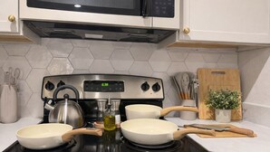 A kitchen with a stove, pots, a kettle, and a microwave. - 4113 Kathrynln2 Plano 2BR (Plano)