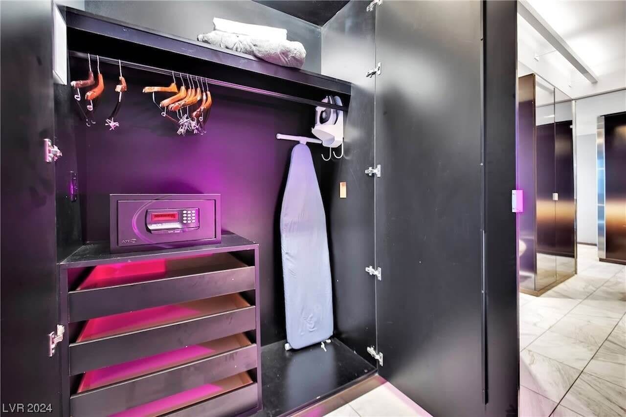A modern bathroom with a black vanity, a towel rack, and a shower area.